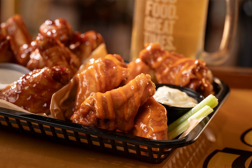 Representative photo: a basket of sauced chicken wings with celery, ranch, and a mug of beer